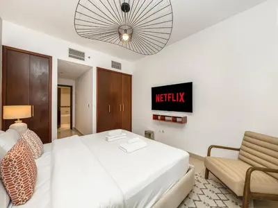 a bedroom with a bed and a couch and a tv at New Burj Khalifa & Fountain Views & Work station in Dubai
