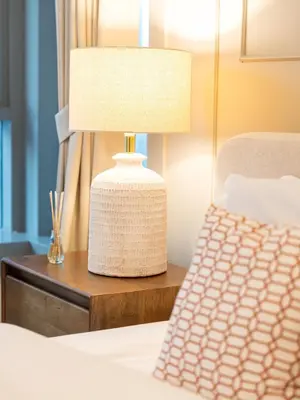 a lamp on a night stand next to a bed at New Burj Khalifa & Fountain Views & Work station in Dubai
