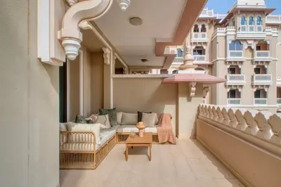 a balcony with couches and a table on a building at The Smart Concierge - Grandeur Residence - Maurya in Dubai