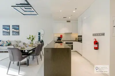 a kitchen and dining room with a table and chairs at 2 Bed Apt in District One Dubai - Lagoon Views in Dubai