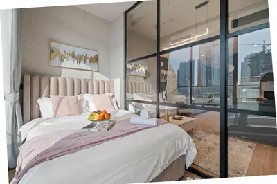 a bedroom with a bed with a bowl of fruit on it at luxury london style studio-loci residences in Dubai