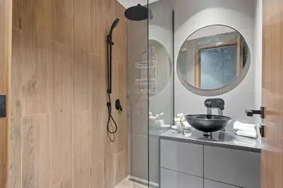 a bathroom with a shower with a sink and a mirror at luxury london style studio-loci residences in Dubai