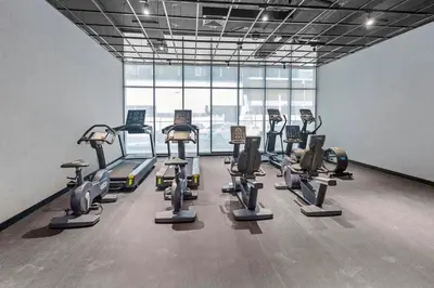 a gym with a bunch of cardio equipment in a room at luxury london style studio-loci residences in Dubai