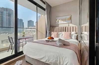 a bedroom with a large bed and a large window at luxury london style studio-loci residences in Dubai
