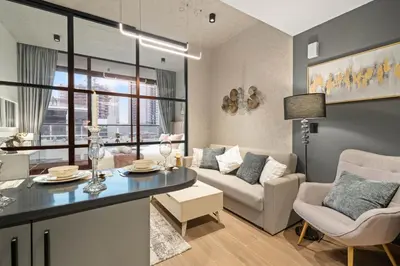 a living room with a couch and a table at luxury london style studio-loci residences in Dubai