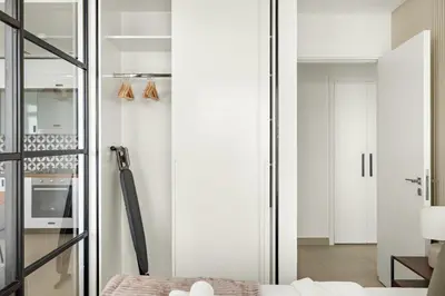 a bedroom with white walls and a glass door at Silkhaus in Collective Tower Luxorious 2BDR in Dubai