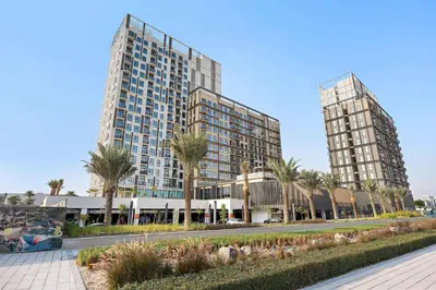 two tall buildings with palm trees in front of a street at Silkhaus in Collective Tower Luxorious 2BDR in Dubai