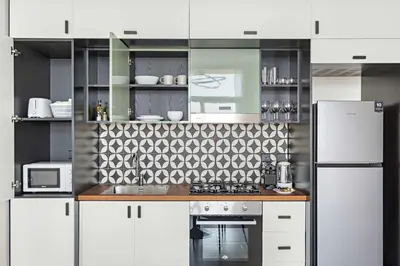 a kitchen with white cabinets and a white refrigerator at Silkhaus in Collective Tower Luxorious 2BDR in Dubai