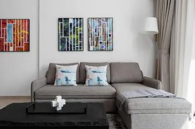 a living room with a couch and a cross on a table at Waves - Luxurious Comfort with City Views in Oxford 212 in Dubai