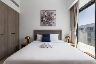 a bedroom with a large bed and a large window at Waves - Luxurious Comfort with City Views in Oxford 212 in Dubai