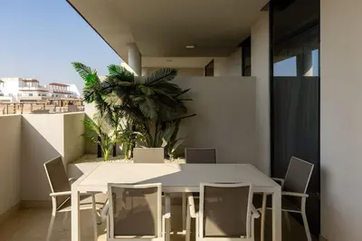 a white dining room table and chairs on a balcony at Waves - Luxurious Comfort with City Views in Oxford 212 in Dubai