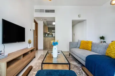 a living room with a couch and a tv at ShoresInn - Fantastic Marina Waterfront View in Dubai