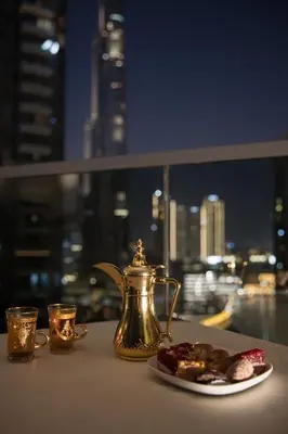 a tea kettle and a plate of cookies on a table at Spacious 3BR plus maids Burj Khalifa View in Dubai