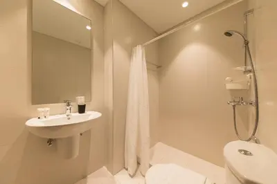 a white bathroom with a sink and a shower at Spacious 3BR plus maids Burj Khalifa View in Dubai