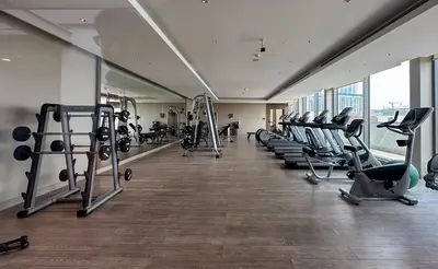 a gym with rows of treadmills and exercise machines at Ahlan HH - Luxury 2BR in Sobha Creek Vistas in Dubai