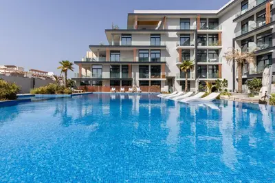 a large swimming pool in front of a building at Waves - Elegant Oxford 212 Studio in JVC with City Views in Dubai