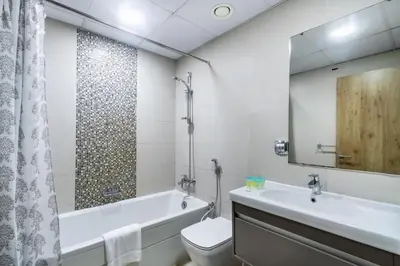 a bathroom with a tub and a toilet and a sink at ShoresInn - Heavenly Escape with Marina View in Dubai