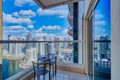 a balcony with two stools and a view of the city at ShoresInn - Heavenly Escape with Marina View in Dubai