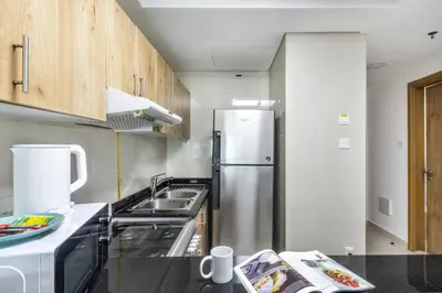 a kitchen with a refrigerator and a sink at ShoresInn - Heavenly Escape with Marina View in Dubai
