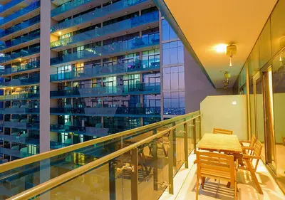 a balcony with a table and chairs and a building at NiceVisit Merano 1BD Business Bay in Dubai