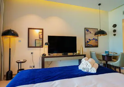 a bedroom with a bed with a television and a desk at NiceVisit Majestine Stuido Business bay in Dubai