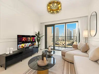 a living room with a couch and a tv at Burj Khalifa View Luxe 2BR, 5 Mins walk to Dubai Mall in Dubai