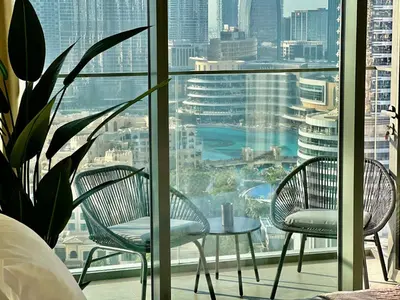 two chairs and a table in front of a window at Burj Khalifa View Luxe 2BR, 5 Mins walk to Dubai Mall in Dubai