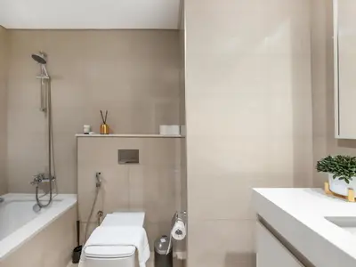 a bathroom with a toilet and a sink and a tub at Burj Khalifa View Luxe 2BR, 5 Mins walk to Dubai Mall in Dubai