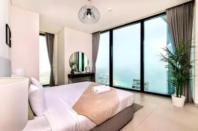 a bedroom with a white bed and large windows at Famous Address JBR HIGH FLOOR Sea View in Dubai
