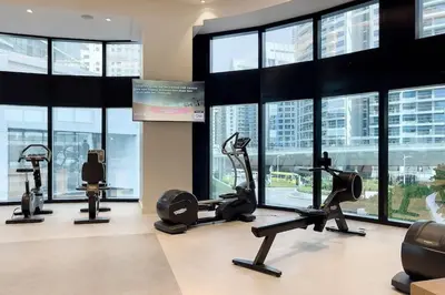 a gym with cardio equipment in a building with windows at Famous Address JBR HIGH FLOOR Sea View in Dubai