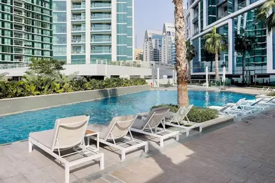 a row of lounge chairs next to a swimming pool at Famous Address JBR HIGH FLOOR Sea View in Dubai