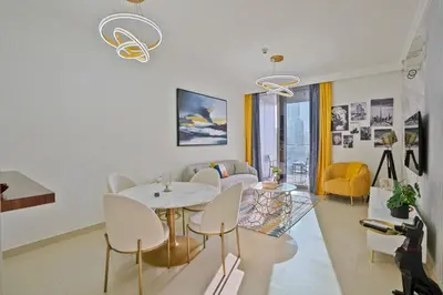 a living room with a table and chairs at CH Skyline Retreat - Cozy 1BR Apt With Burj Khalifa and Fountain Views in Dubai