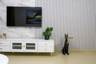 a room with a white dresser with a tv on a wall at CH Skyline Retreat - Cozy 1BR Apt With Burj Khalifa and Fountain Views in Dubai
