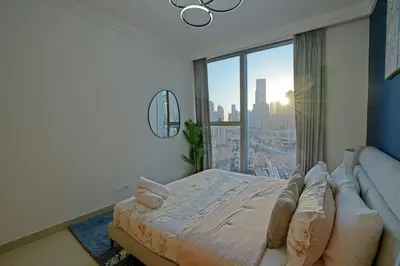 a bedroom with a bed and a large window at CH Skyline Retreat - Cozy 1BR Apt With Burj Khalifa and Fountain Views in Dubai