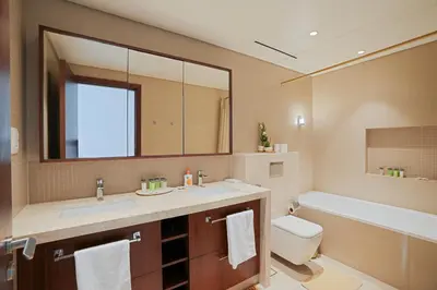 a bathroom with a sink and a toilet and a mirror at CH Skyline Retreat - Cozy 1BR Apt With Burj Khalifa and Fountain Views in Dubai