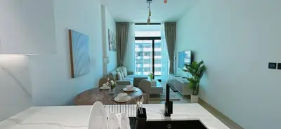 a living room with a table and a couch at Stylish 1br Apartment Jvc Pool Parking in Dubai