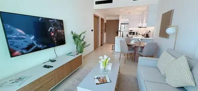 a living room with a large flat screen tv on a wall at Stylish 1br Apartment Jvc Pool Parking in Dubai