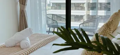 a room with a bed with a plant and a balcony at Stylish 1br Apartment Jvc Pool Parking in Dubai