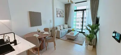 a living room with a table and a living room with a couch at Stylish 1br Apartment Jvc Pool Parking in Dubai