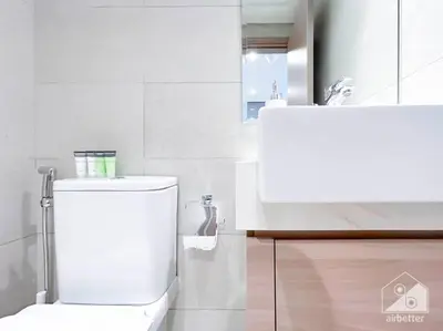 a white bathroom with a toilet and a sink at Elegant 1BR with Balcony in Azizi Riviera in Dubai