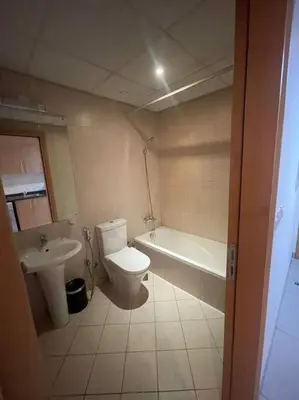 a bathroom with a toilet and a tub and a sink at Studio Apartment in Dubai in Dubai