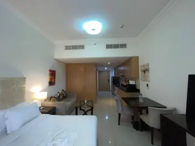 a hotel room with a bed and a living room at Studio Apartment in Dubai in Dubai