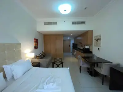 a bedroom with a bed and a living room with a kitchen at Studio Apartment in Dubai in Dubai