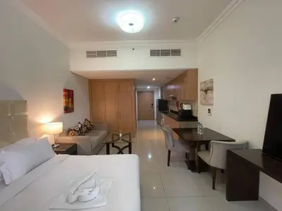 a hotel room with a bed and a living room at Studio Apartment in Dubai in Dubai