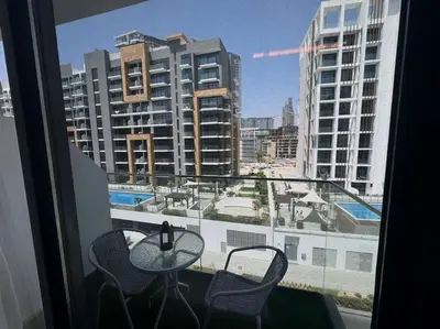 a balcony with a table and chairs and a view of a city at Stunning Studio in Meydan Azizi 42 in Dubai