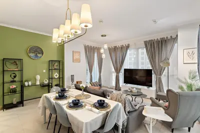 a living room with a table and a tv at Downtown Gem, Fountain View! in Dubai