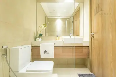 a bathroom with a toilet and a sink and a mirror at Chic 2BR with Partial Burj Khalifa View in Dubai