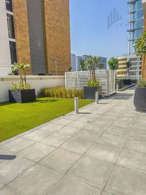 a sidewalk in front of a building with plants at Chic 2BR with Partial Burj Khalifa View in Dubai