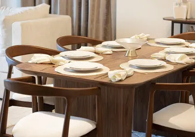 a wooden table with plates and napkins on it at Luxury Apartment with Full Burj Khalifa and Downtown Views in Dubai