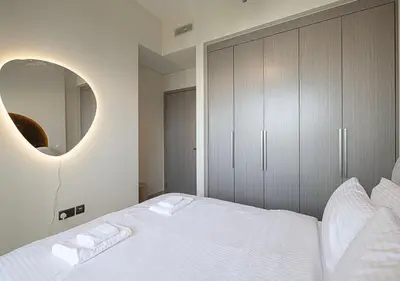a bedroom with a large white bed with a mirror at Luxury Apartment with Full Burj Khalifa and Downtown Views in Dubai